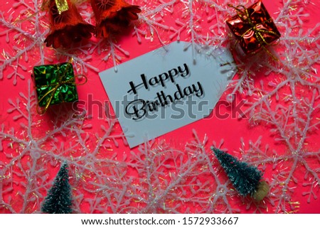 Happy Birthday write on label with Pink backgroud. It means Best Wishes. Frame of Christmas Decoration.
