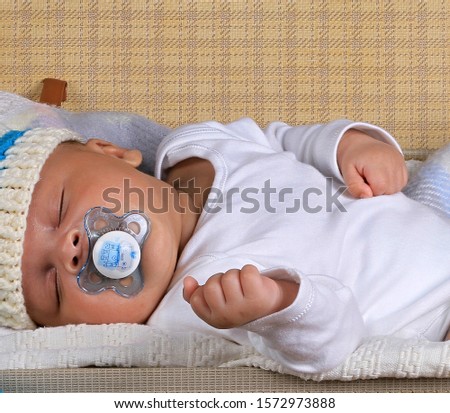 baby sleeping wrapped up in blanket just been cared for after having a good sleep in bed  on white background stock photo
