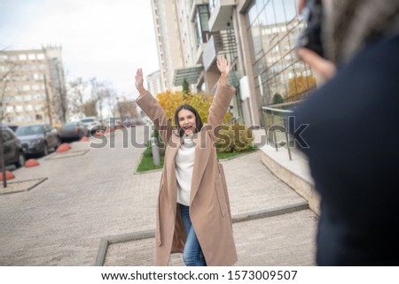 Sincere happiness. Happy positive woman holding her hands up while showing her emotions on camera