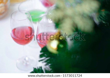 Christmas & 2020 New year party setting with wine glasses and Christmas tree in background. Drinking wine in New year party is fun way to celebrate the festive seasons. Cheerful celebration concept.