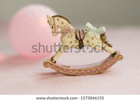 Christmas decoration, rocking horse on a pink background, Christmas tree toy
