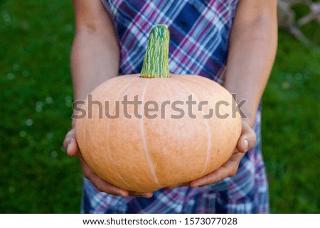 Woman holding a big pumpkin. Rich harvest. Agriculture and farming.