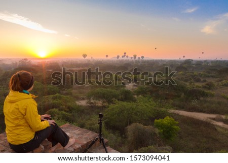A young woman sits alone at sunrise in Bagan, Myanmar