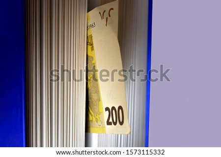 200 Euro in blu book on gray background. Education investment concept, money saving concept. Macro photo with copoy space