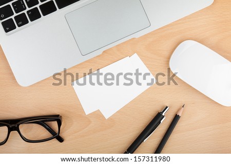 Blank business cards with supplies on wooden office table