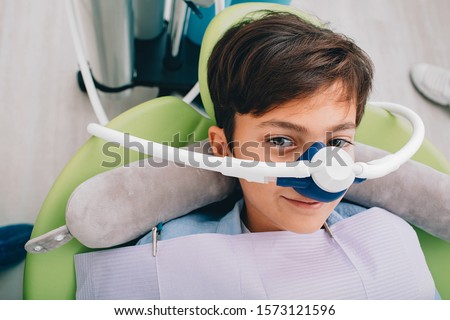 Little boy getting Inhalation Sedation while teeth treatment at dental clinic. Teeth treatment child Royalty-Free Stock Photo #1573121596