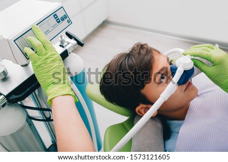 Little boy getting Inhalation Sedation while teeth treatment at dental clinic. Teeth treatment child Royalty-Free Stock Photo #1573121605