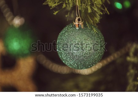 Christmas tree close up of decorations with baubles, bells, beads and lights
