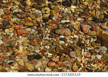 Italy: Small colored stones in the Sardinian sea.