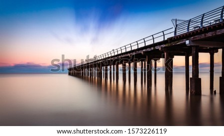 Long exposure sunset over the Felixstowe pier Royalty-Free Stock Photo #1573226119