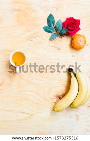 Fresh banana and persimmon in brick wall background and wooden table, tropical fruit, healthy food.