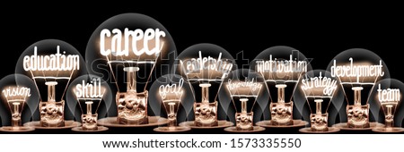 Large group of light bulbs with shining fibers in a shape of Career, Leadership, Motivation, Education and Development concept related words isolated on black background Royalty-Free Stock Photo #1573335550