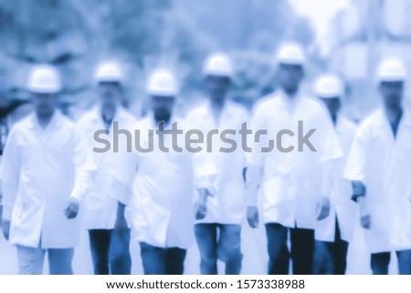 Abstract, blurry, bokeh background, image for the background. People in overalls in production