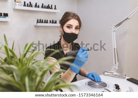 Young beautiful manicurist waiting for clients at beauty salon
