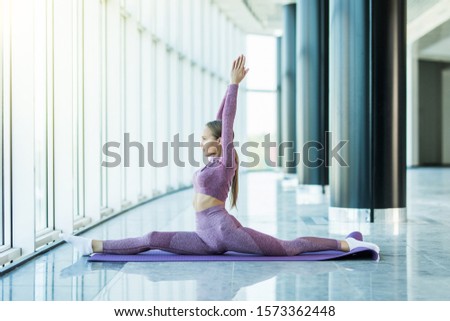 Sporty young woman doing yoga practice isolated on class background. Concept of healthy life and natural balance between body and mental development. Full length