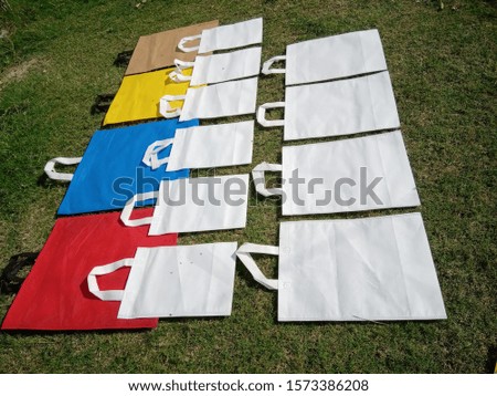isolated Non Woven Polypropylene Bags on green grass background, Eco Friendly Bags, Reusable bag, Shopping & Gift Bags, Environment Friendly Concept. Reduce, Reuse, Recycle