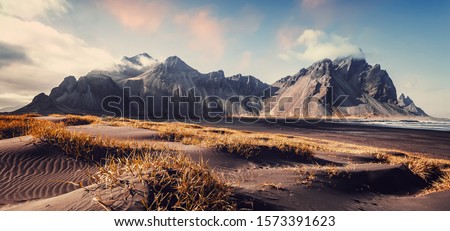 Vestrahorn mountaine on Stokksnes cape in Iceland during sunset. Amazing Iceland nature seascape. popular tourist attraction. Best famouse travel locations. Scenic Image of Iceland Royalty-Free Stock Photo #1573391623