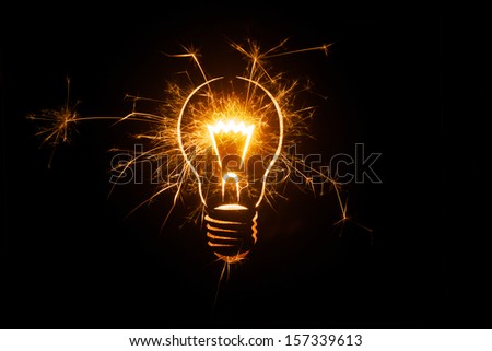 Sparkling light bulb on black background with ample copy space. Royalty-Free Stock Photo #157339613