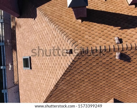 House with a roof from a bituminous tile. Bituminous tile for a roof. a roof from a bituminous tile.