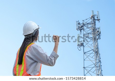 successful female engineer standing at the background of the communication tower