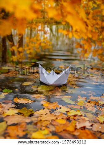 paper boat on an autumn river close up