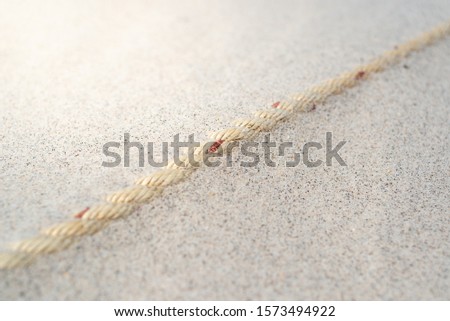 Rope of boat on the sand of a beach.