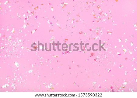 Pearl confetti on pink background. Flat lay, top view.