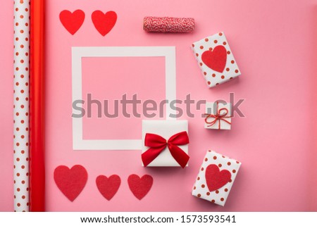 Valentines day, wedding or other holiday composition. Handmade wrapped gift boxes, red hearts and diy tools on pink background with copy space for text. Flat lay