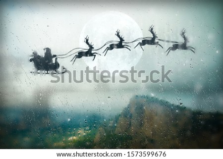 Santa flying on sky over over the mountains. Marry Christmas and happy holiday.