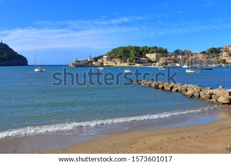 Pictured is a cozy bay of the evergreen island of Palma de Mallorca. On the blue surface of the bay are visible anchored boats.