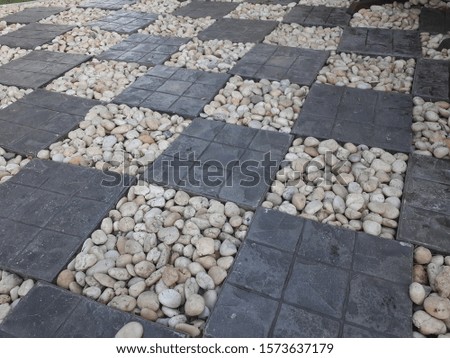 The walkway in the garden is decorated with stones and stone tiles arranged beautifully.