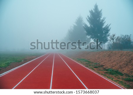Athlete Track or Running Track in autumn nature. Blue misty background. White edit space