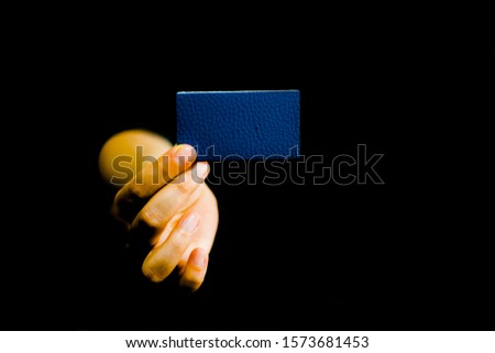 Hands holding a blue thick blank paper