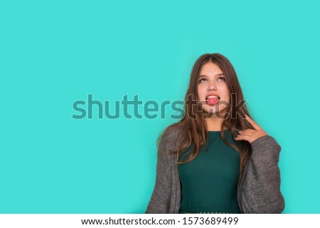 Portrait of cute teenage nice-looking cute lovely adorable sweet attractive cheerful cheery girl showing v-sign isolated over blue pastel background. showing peace gesture