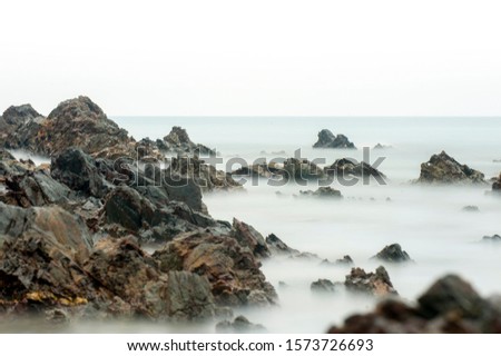 Long exposure seascape and rocky beach. A slow shutter speed was used to see the movement ( Soft focus due to long exposure shot ) soft and grain effect.
