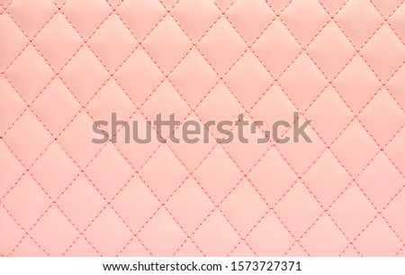Natural leather background colored in pink and sewn in the form of rhombus. Top view, copy space . Royalty-Free Stock Photo #1573727371