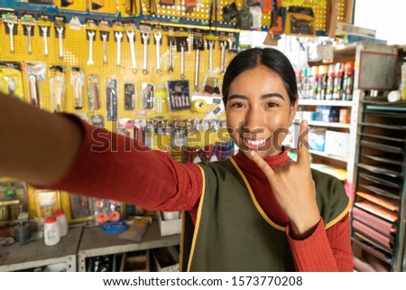 Smiling real worker taking a selfie a hardware store. interior detail