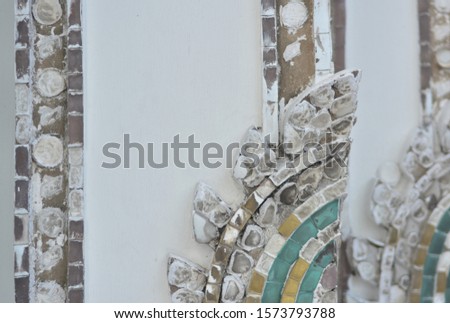 Sculpture decorated ceramic lotus petals covering the wall.