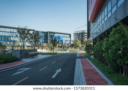 empty footpath with modern office building exterior and blue cloudy sky during sunrise
