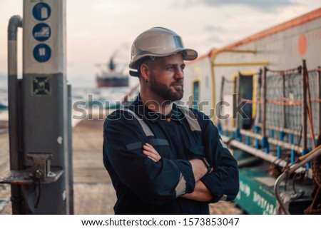 Marine Deck Officer or Chief mate on deck of offshore vessel or ship , wearing PPE personal protective equipment - helmet, coverall Royalty-Free Stock Photo #1573853047