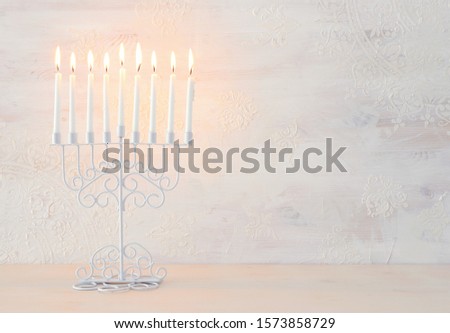 Religion image of jewish holiday Hanukkah with menorah (traditional candelabra) and candles over white background