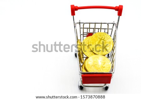 A shopping cart carrying golden bitcoin isolated on white background. A cart is a vehicle designed for transport for carring something. 