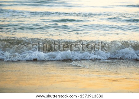 The sea with waves hit the sandy beach in the morning, with copy space text