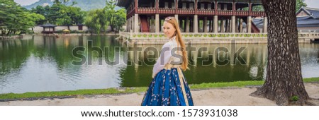 Young caucasian female tourist in hanbok national korean dress Travel to Korea concept. National Korean clothing. Entertainment for tourists - trying on national Korean clothing BANNER, LONG FORMAT