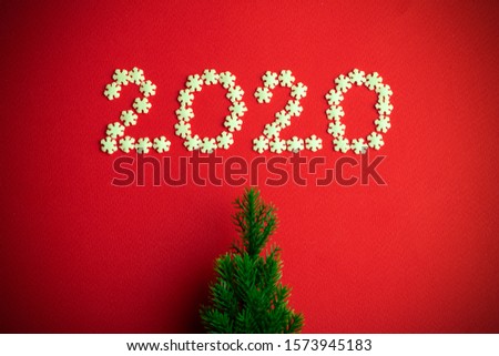 New Year 2020. Creative number 2020 written in white snowflakes on a red background for design. New Year 2020 concept.