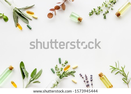 Apothecary of natural wellness and self-care. Herbs and medicine on white background top view frame copy space Royalty-Free Stock Photo #1573945444