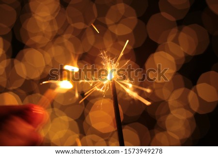 Sparkler and many sparks, macro photo festive bokeh background Christmas and New Year