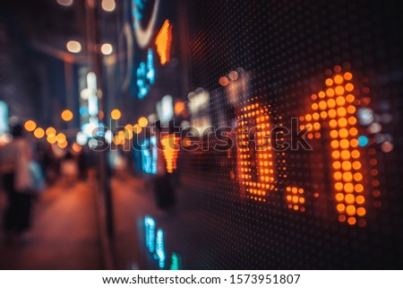 Financial stock exchange market display screen board on the street  with city scene reflect on glass
