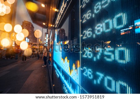 Financial stock exchange market display screen board on the street  with city scene reflect on glass
