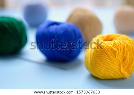 Bright color yarn clews on the blue background. Concept of amigurumi toy making, knitting, handicraft, hobbie.